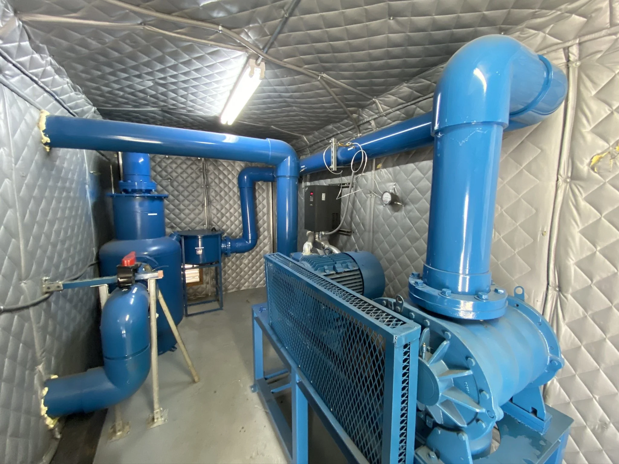 Soil vapor extraction system with electric blower, piping network, and acoustic enclosure installed for environmental remediation
