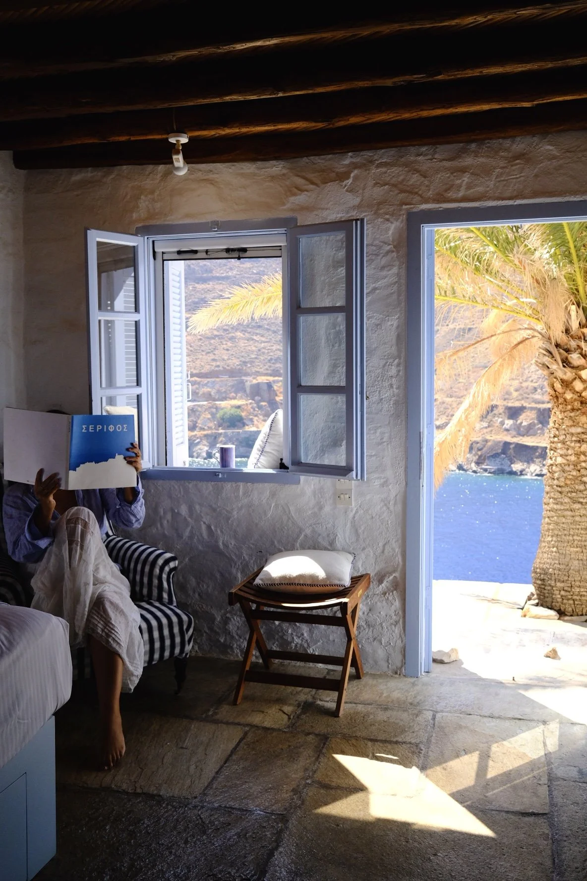 A quiet morning reading in a stone guesthouse on Serifos, Greece