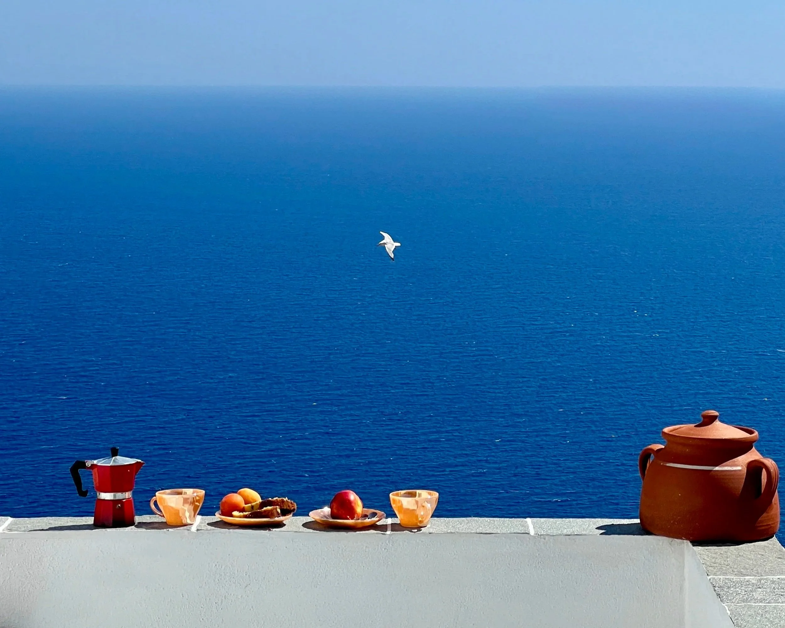 A small wooden boat anchored in the turquoise water of Milos, Greece