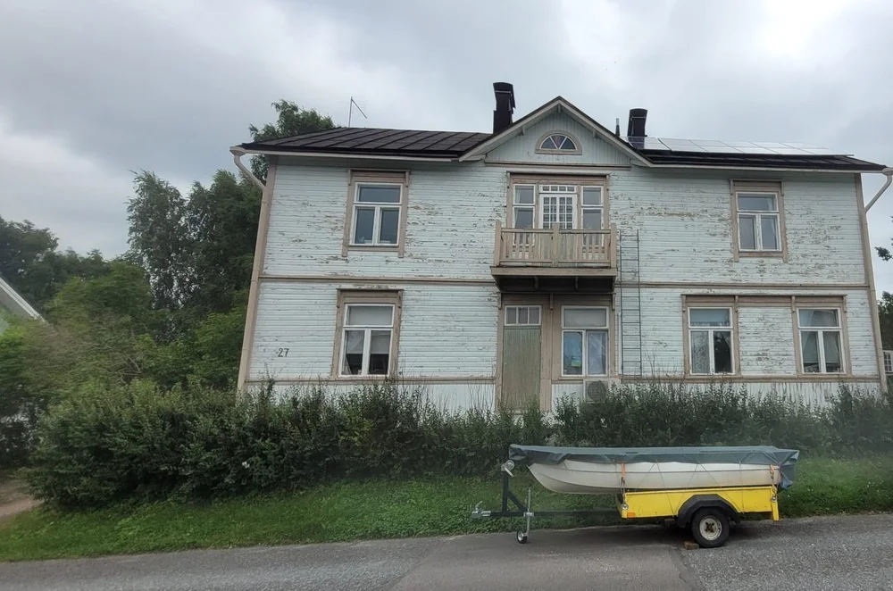 Vanhan kaksikerroksisen puutalon julkisivu ennen maalausta, maali hilseilee