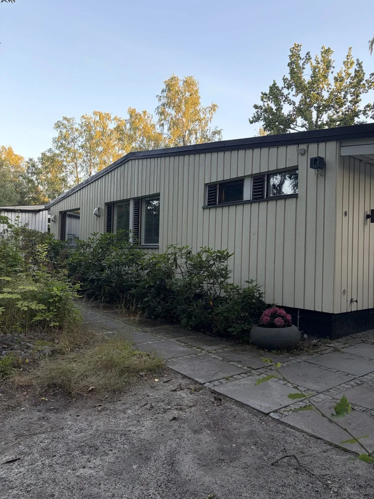 Vaaleanvihreä pystypaneloitu omakotitalo maalattuna