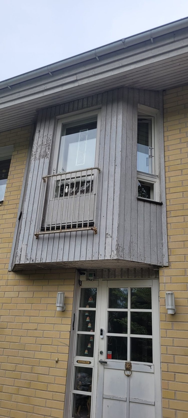 Tiilitalon puinen erkkeri harmaantuneena ennen maalausta