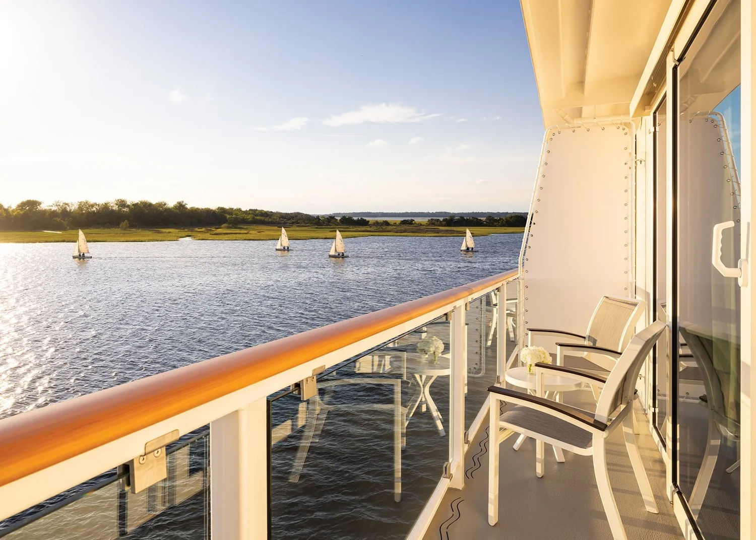American Cruise Lines balcony stateroom with seating area and river view