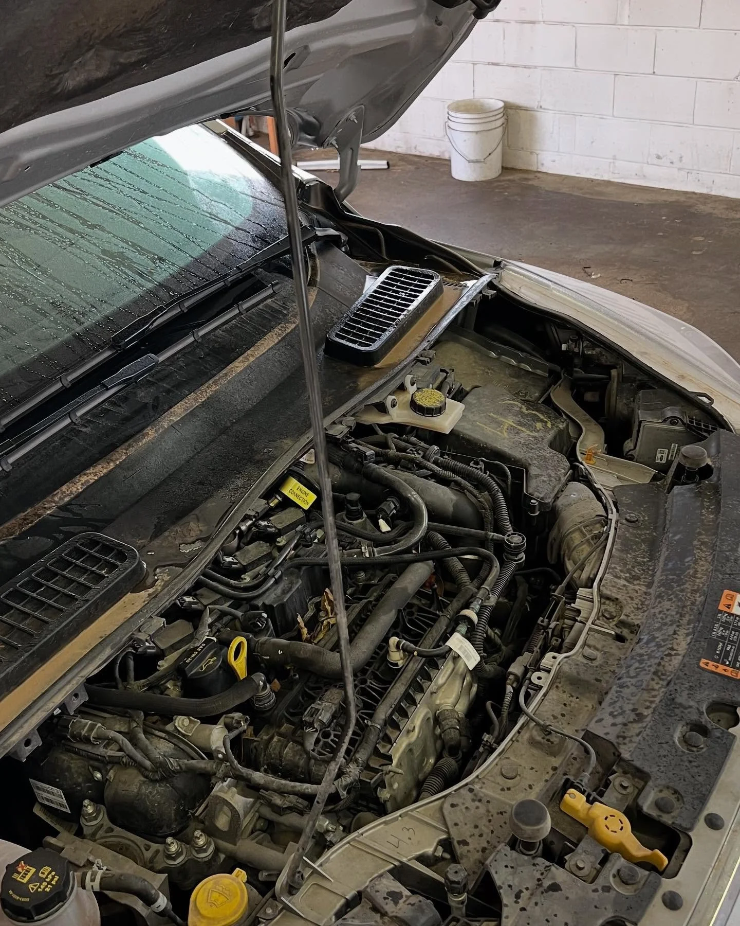 Before engine bay cleaning: dusty plastics and visible grime – MC Auto Detailing, Lincoln NE