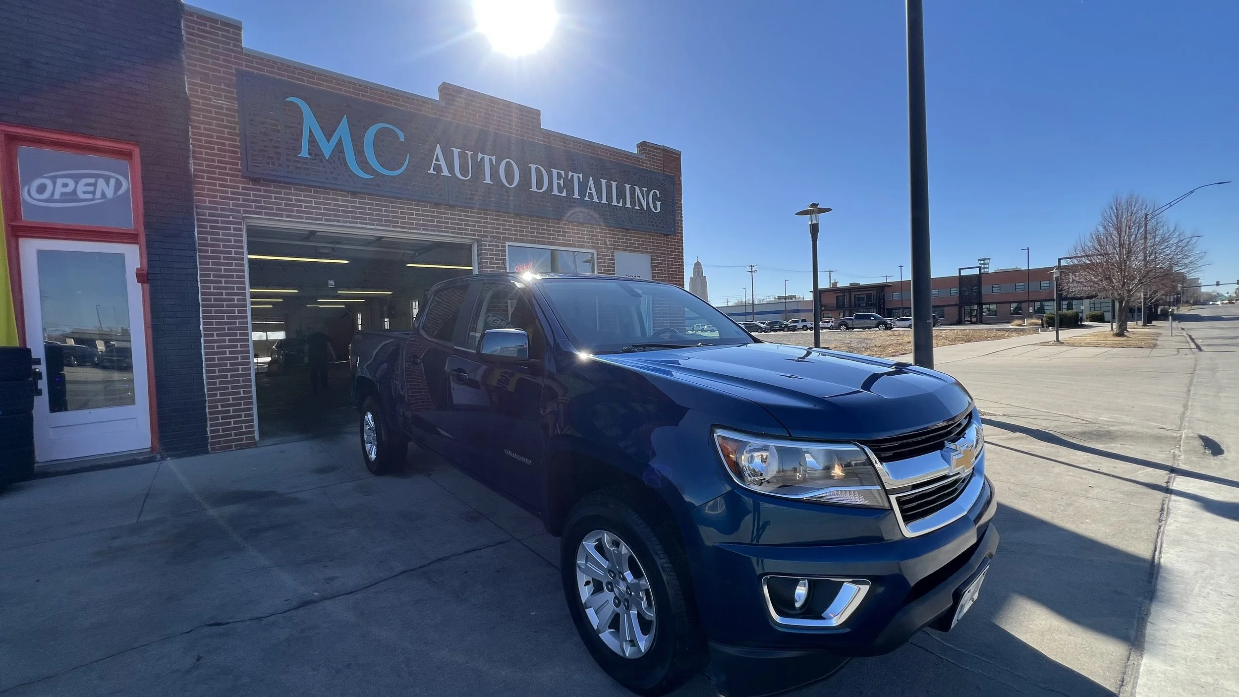 MC Auto Detailing shop front on O Street Lincoln NE with freshly detailed Chevy Colorado