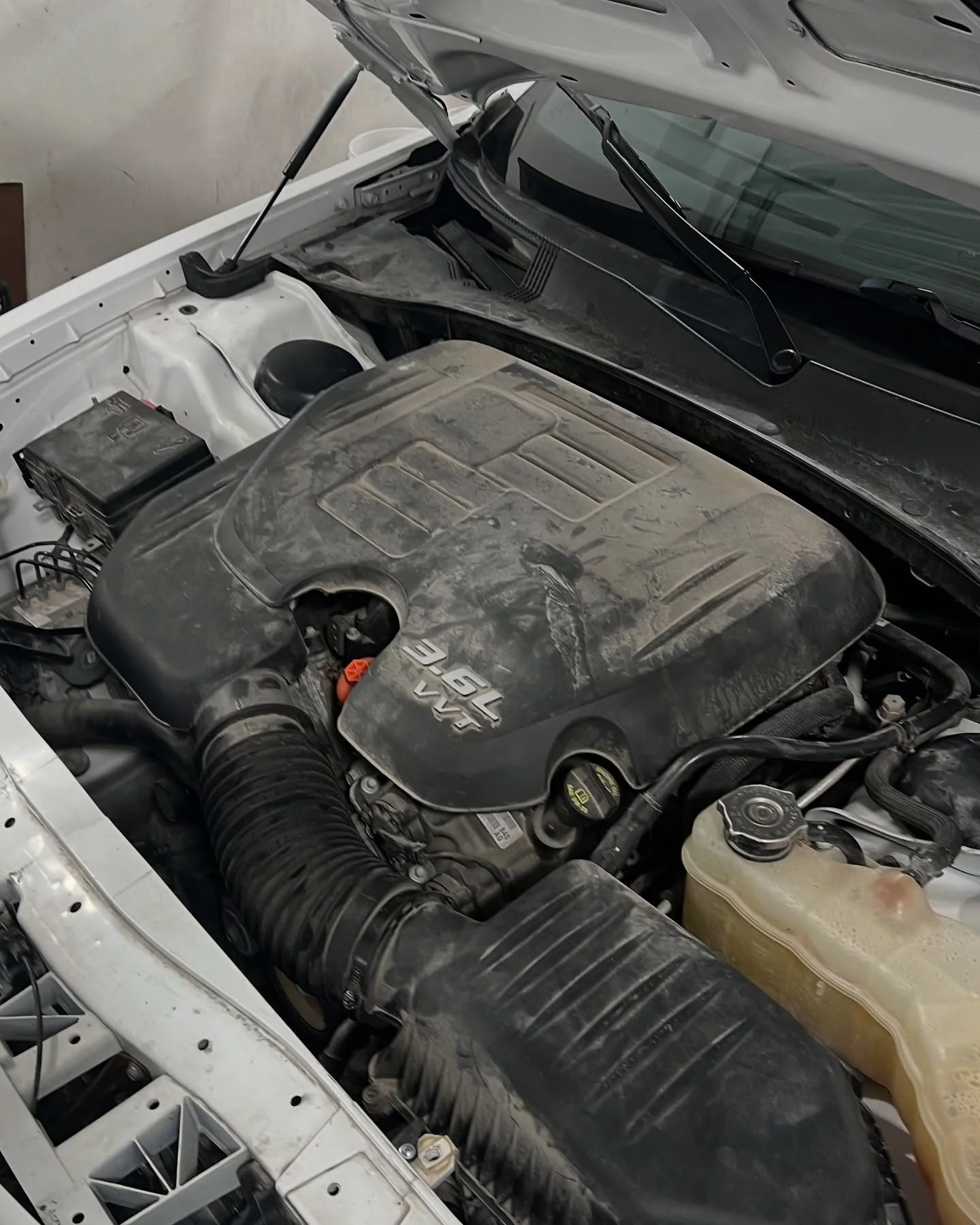 Engine bay before: accumulated dirt around caps and covers – MC Auto Detailing Lincoln NE
