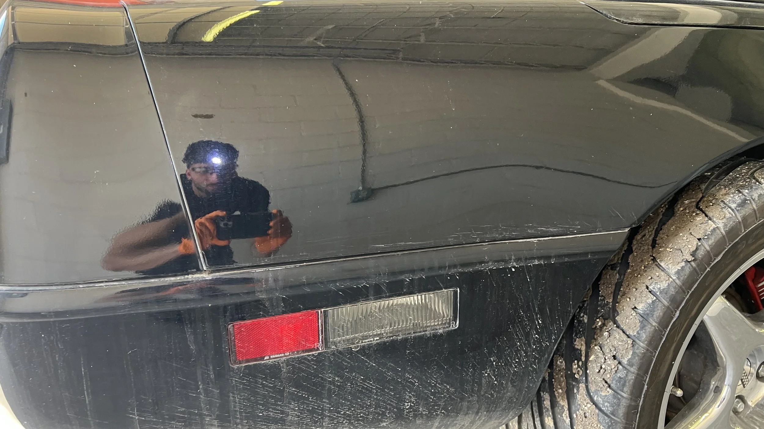 Ahmed owner of MC Auto Detailing inspecting a Corvette in Lincoln NE