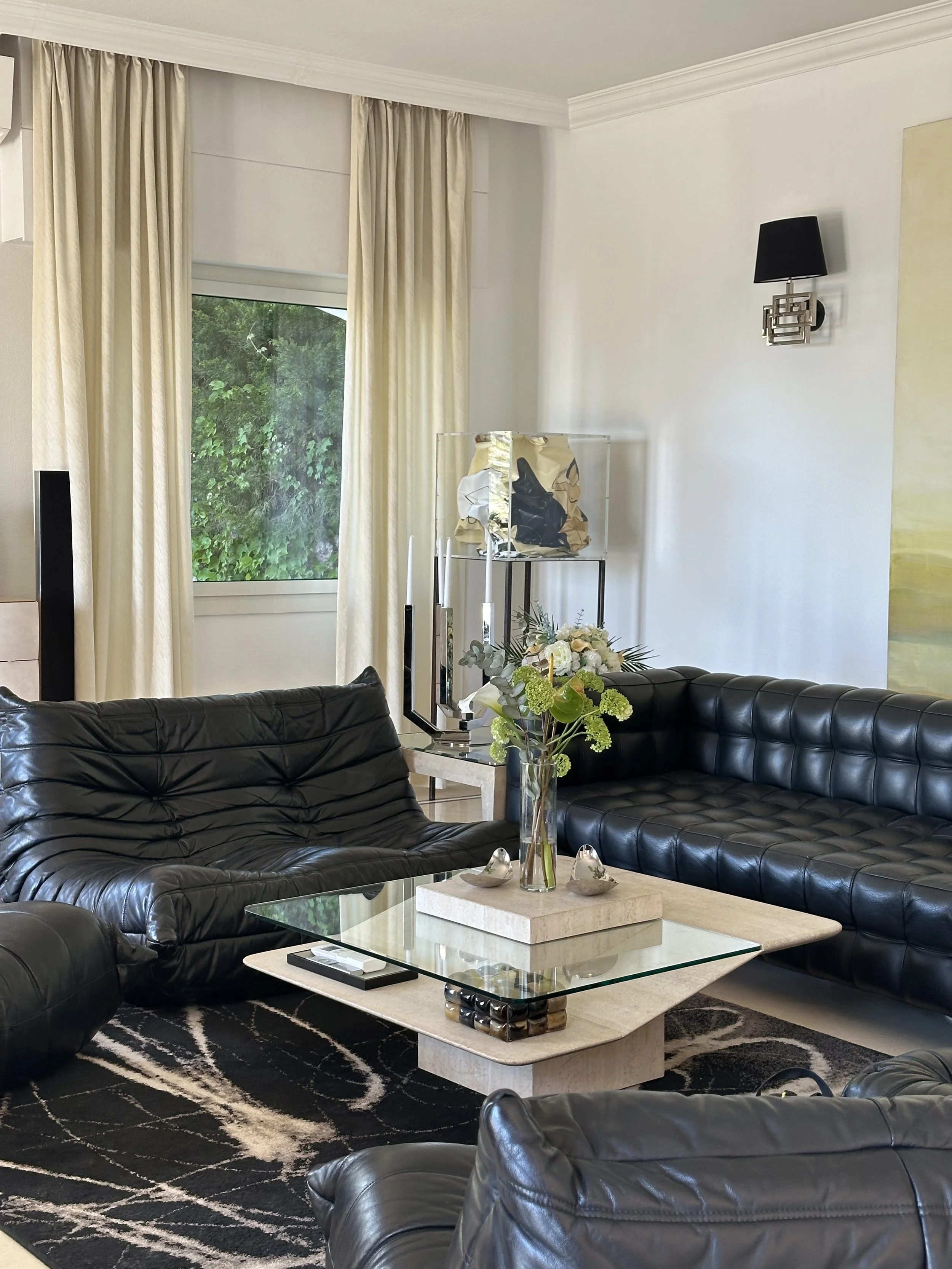 The Villa Monaco living room, arranged around two low, quilted Togo sofas by Michel Ducaroy for Ligne Roset — one of the most celebrated pieces of modern French furniture