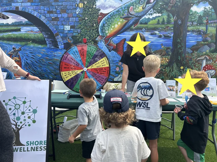 Children approach the SSDW table On the Green at Hanover Crossing.