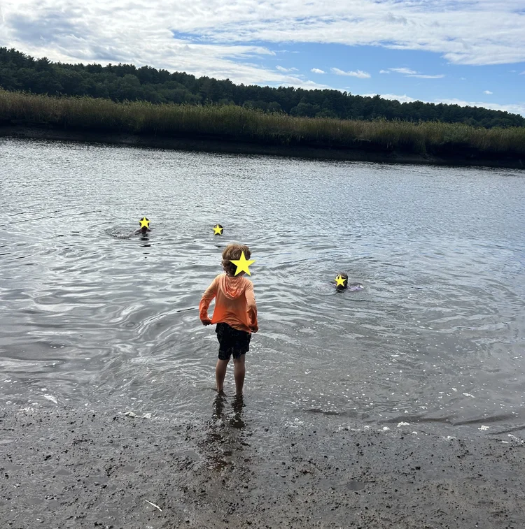 Children swimming and playing in a river.