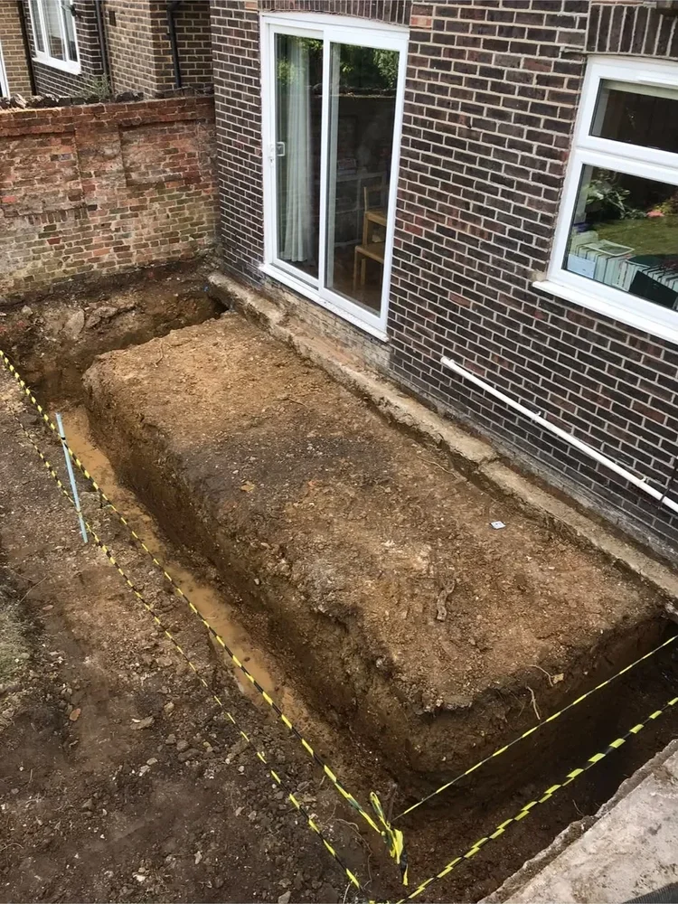 Foundation excavation for a house extension beside a brick property