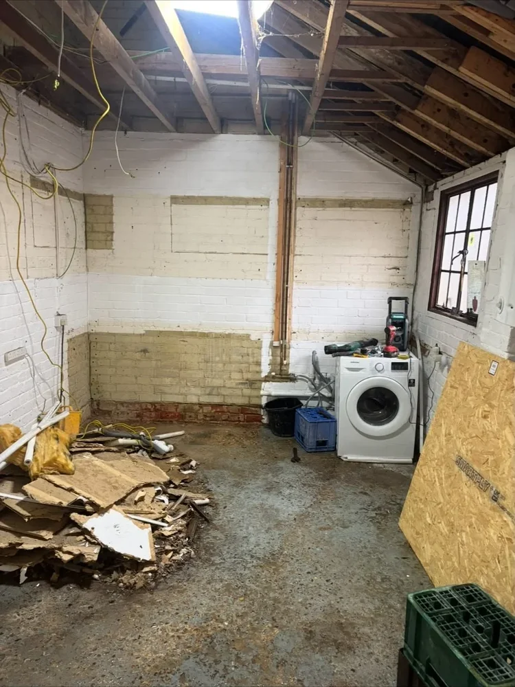 Exposed roof timbers and pipework inside a room awaiting refurbishment