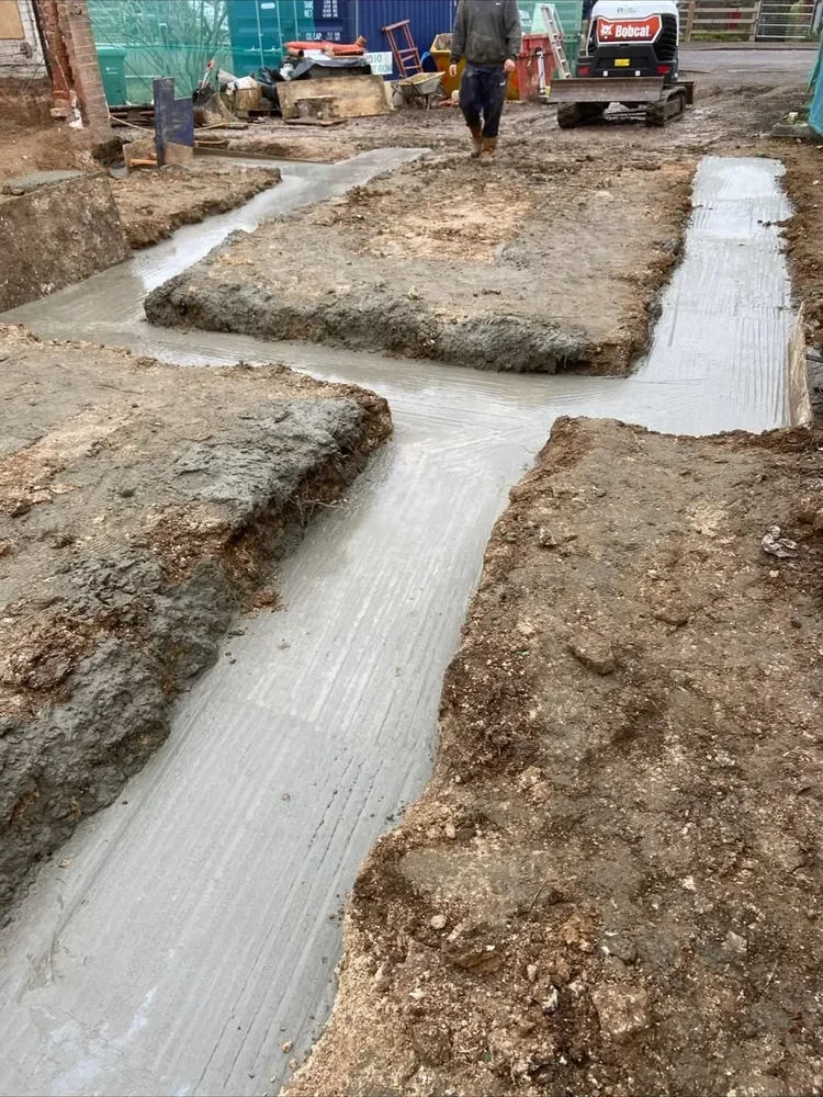 Concrete foundation trenches poured with a mini excavator on site