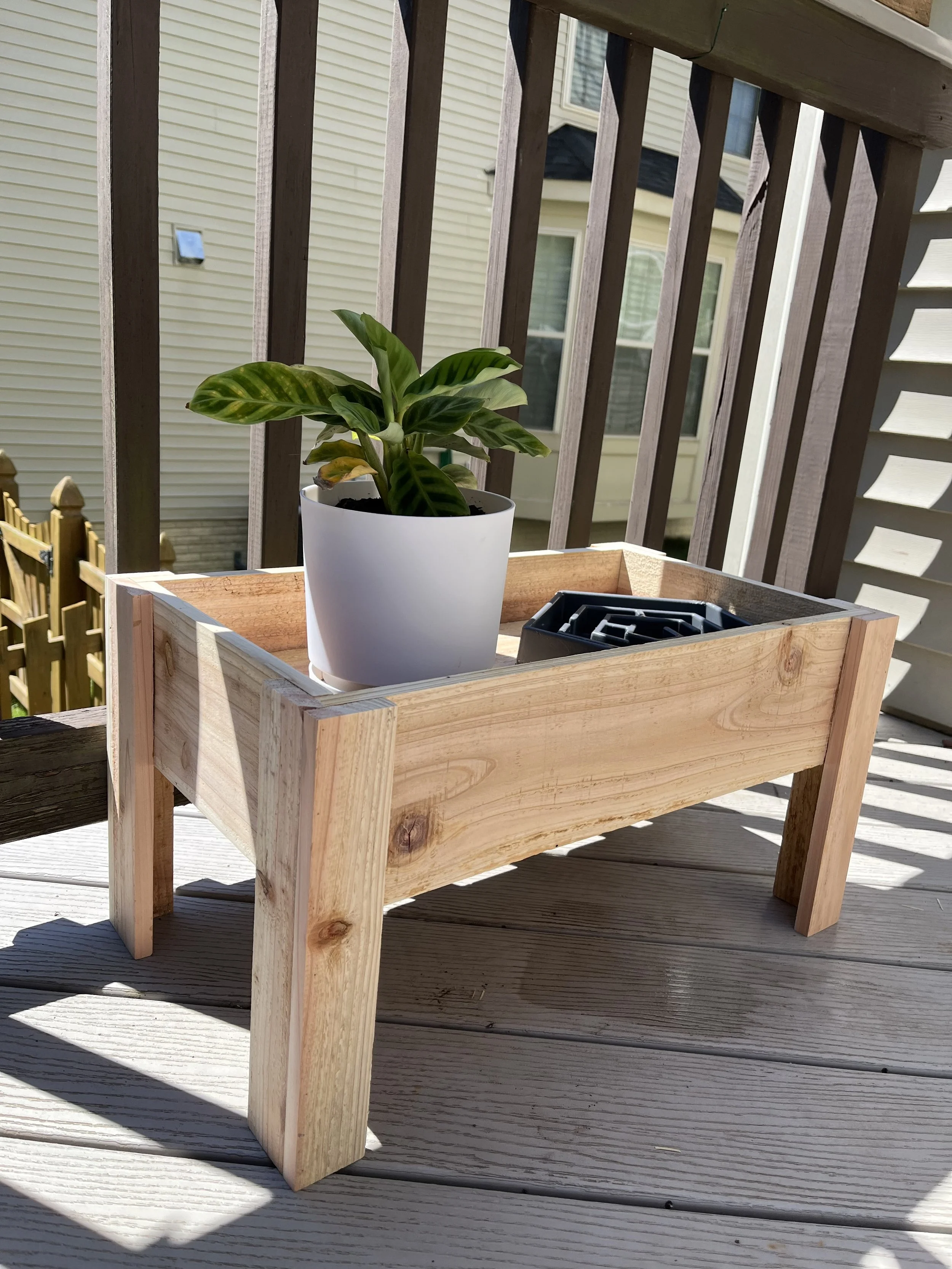 Handcrafted wooden plant stand on a sunlit porch