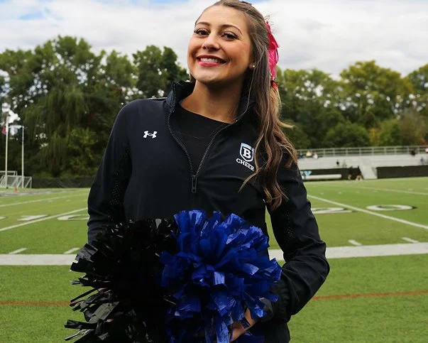 tanned woman cheerleader smiling