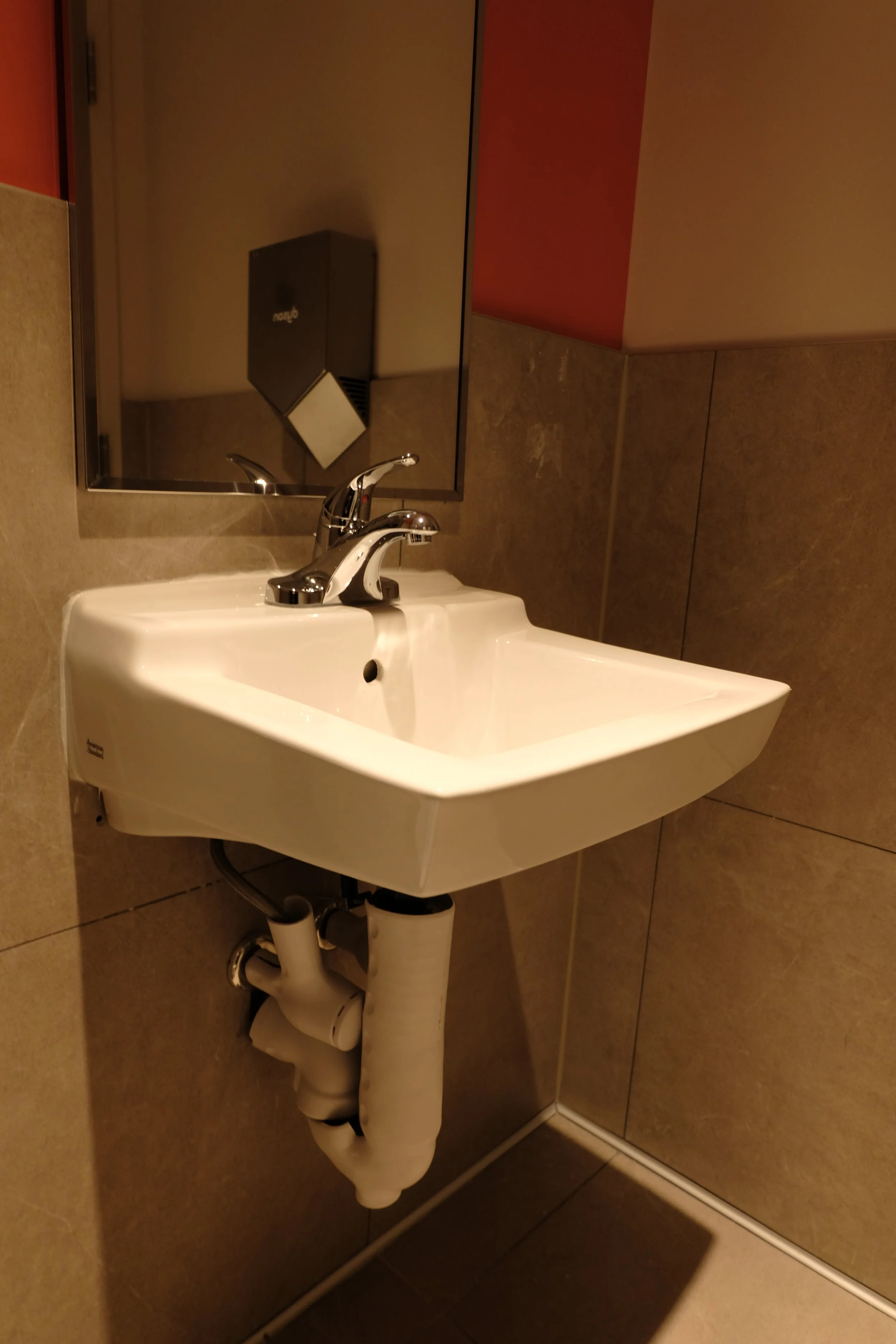Commercial washroom plumbing — wall-mounted sink and toilet