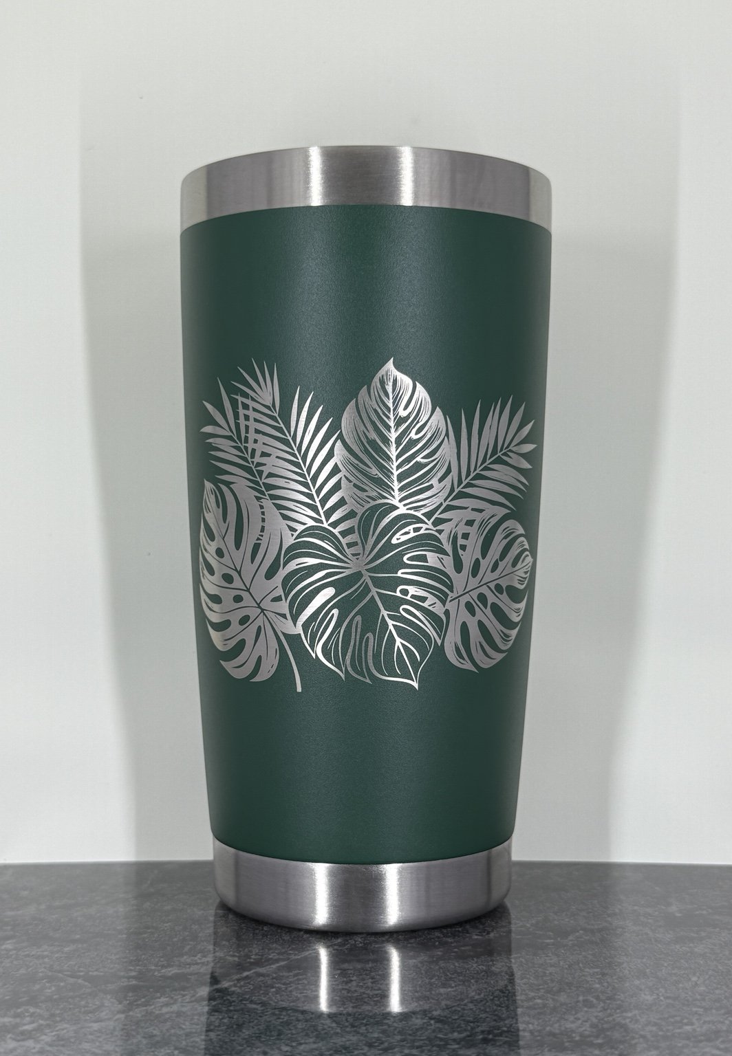 Green tumbler with tropical leaf engraving