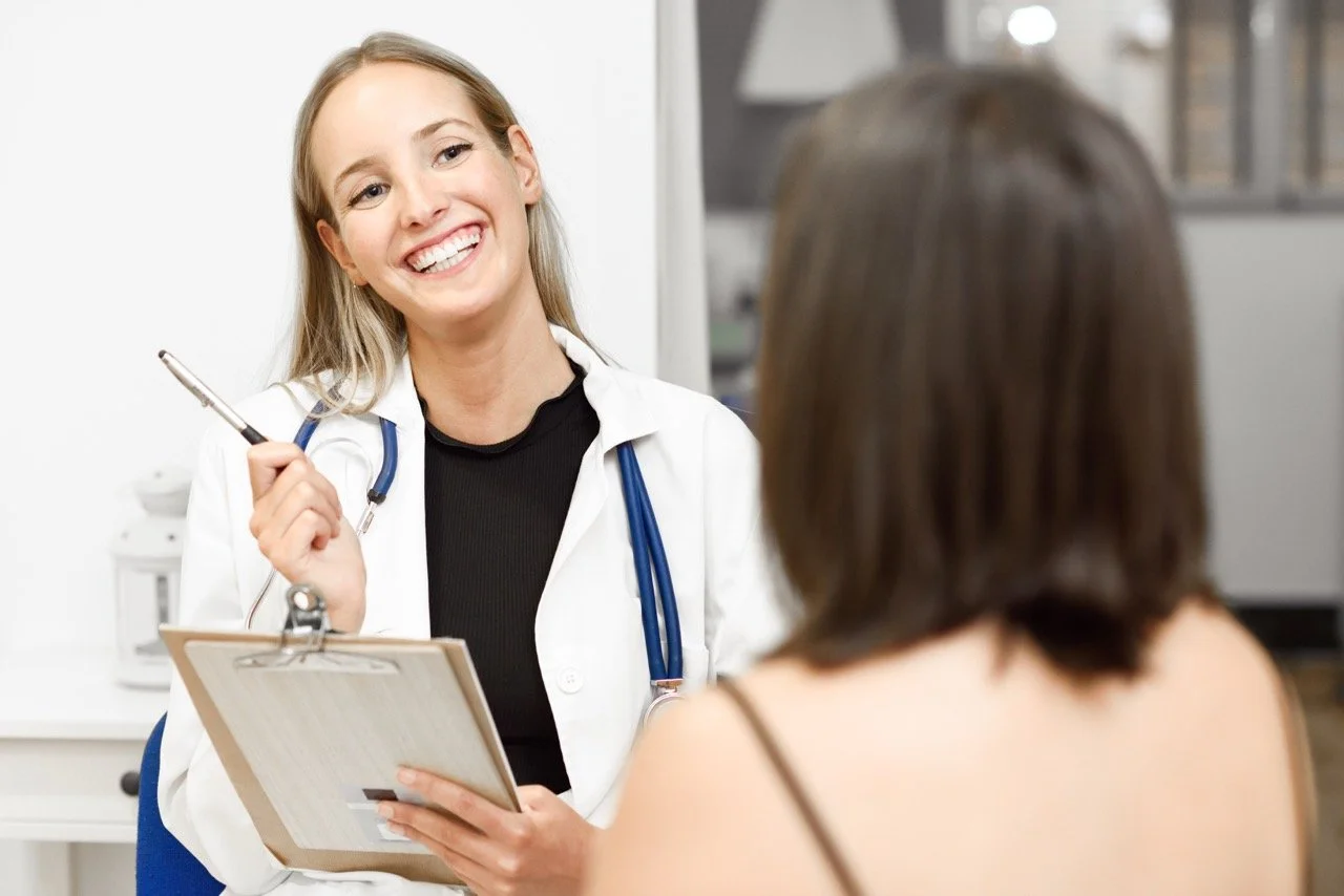 Medical aesthetic practitioner consulting with a client in a clinic