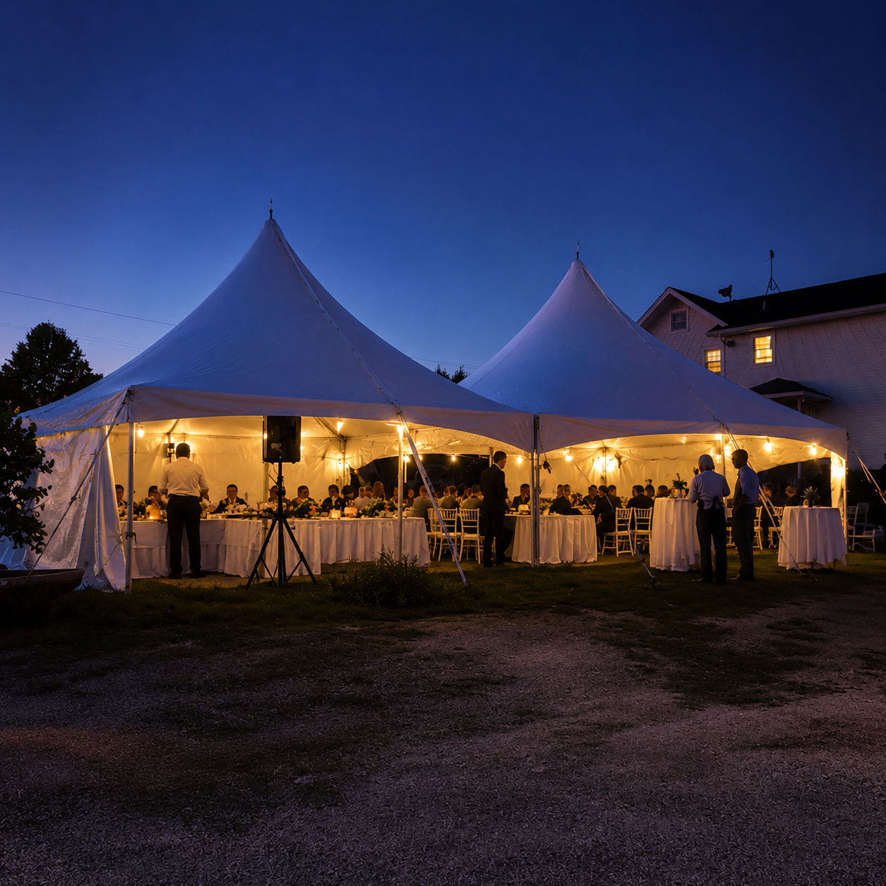 Evening event beneath two connected twenty-by-twenty high-peak tents