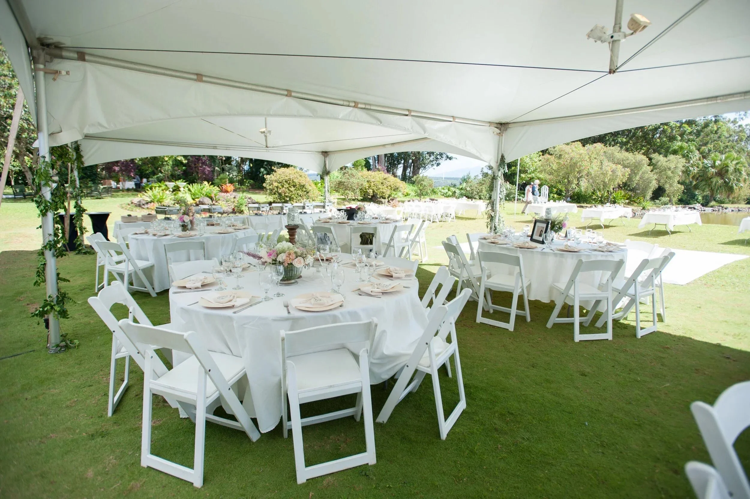Round guest tables prepared for an elegant tented reception