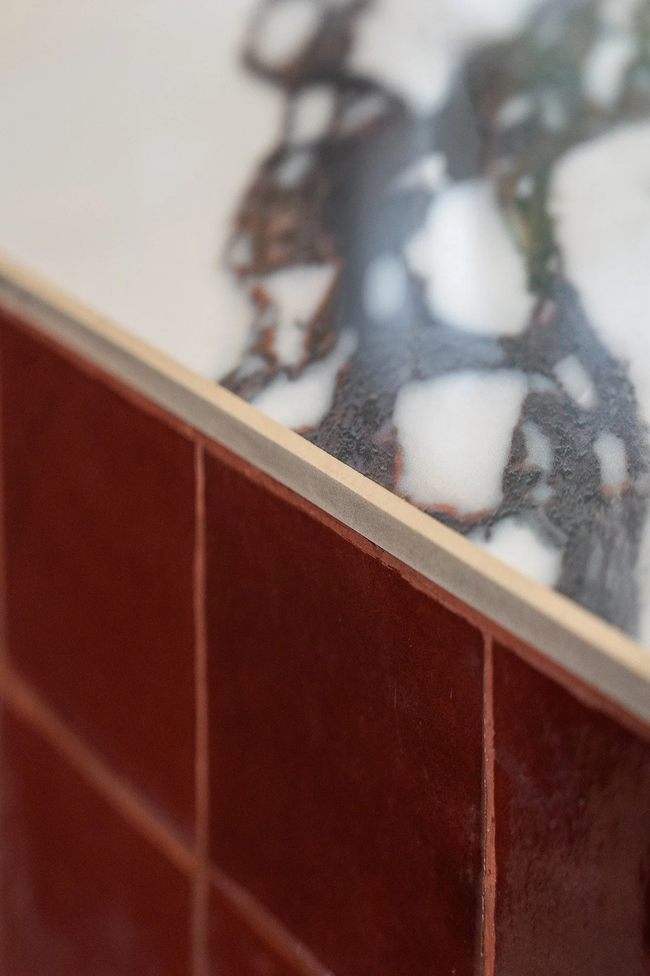 Détail de marbre et de zellige bordeaux au Buzzati’s