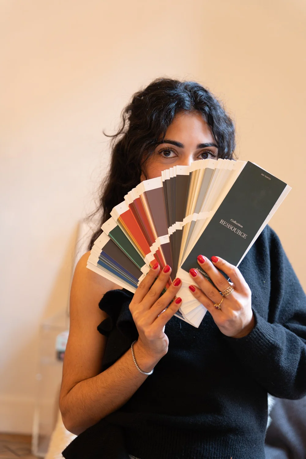 Kenza Benlyazid avec un nuancier devant le visage, fondatrice de Maison Trésor Studio
