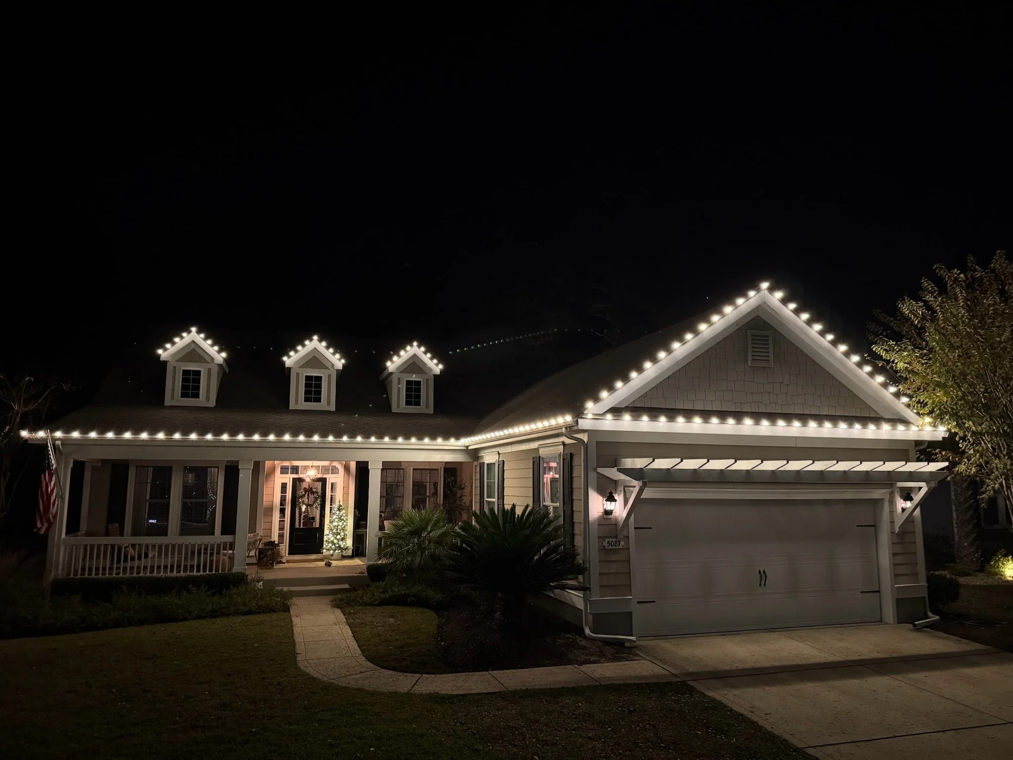 Warm white roofline Christmas lights installed by Kraken Harbor