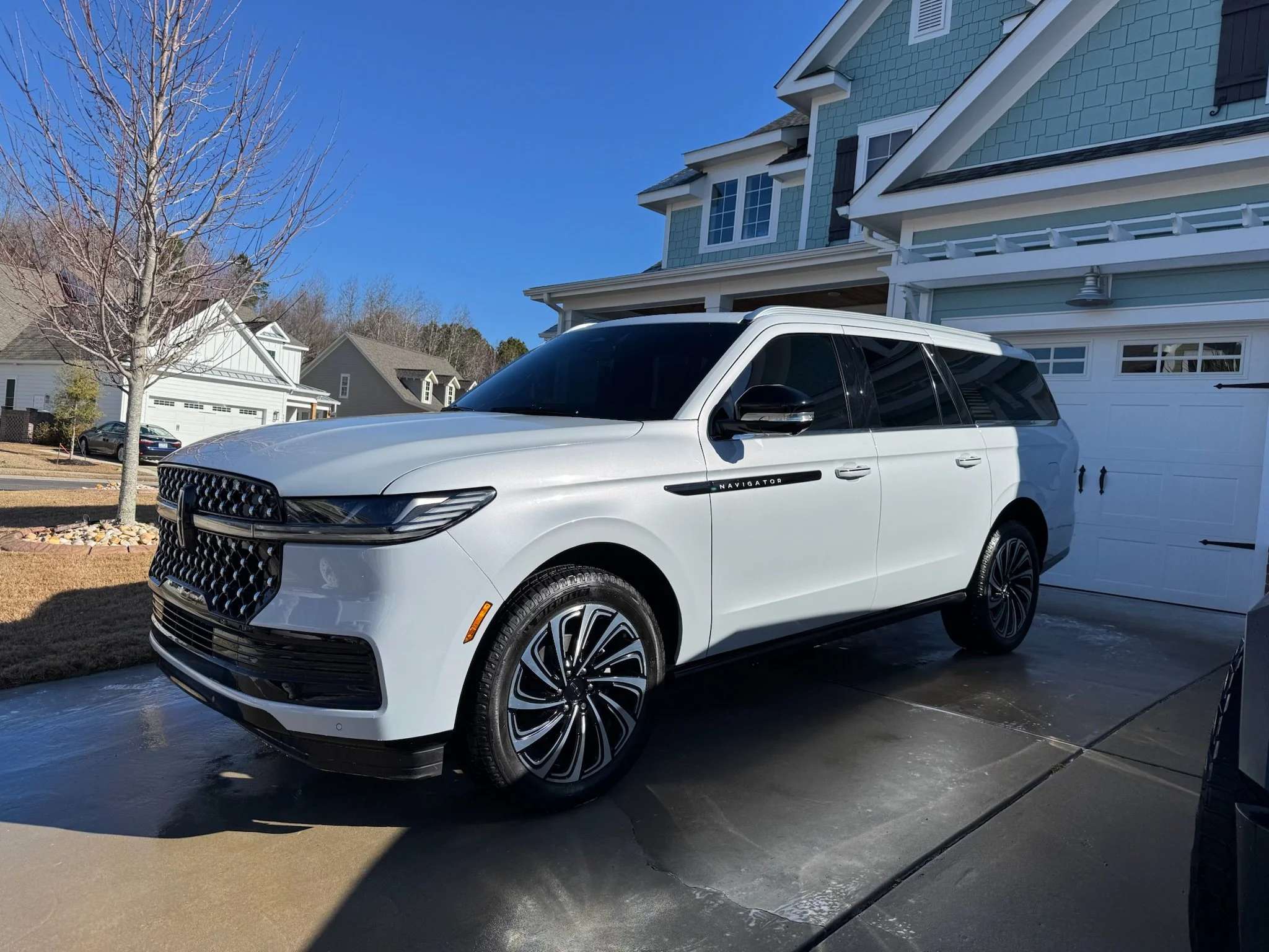 White Lincoln freshly detailed in a client's driveway
