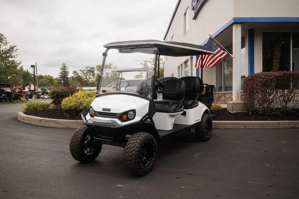 White six-passenger golf cart outside Golf Cars Unlimited