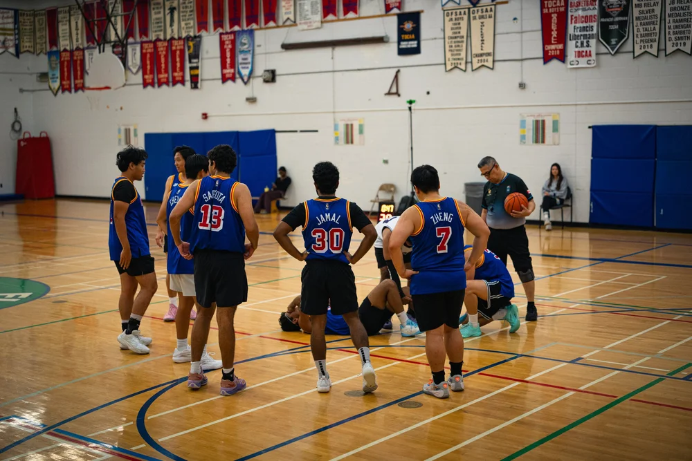Warriors teammates and an official gather around a player lying on the basketball court.