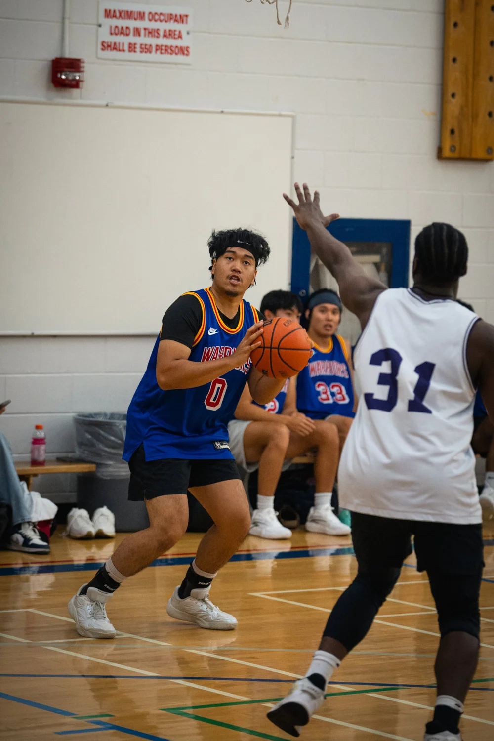 Warriors number 0 gathers the basketball as Icons B number 31 raises a hand.