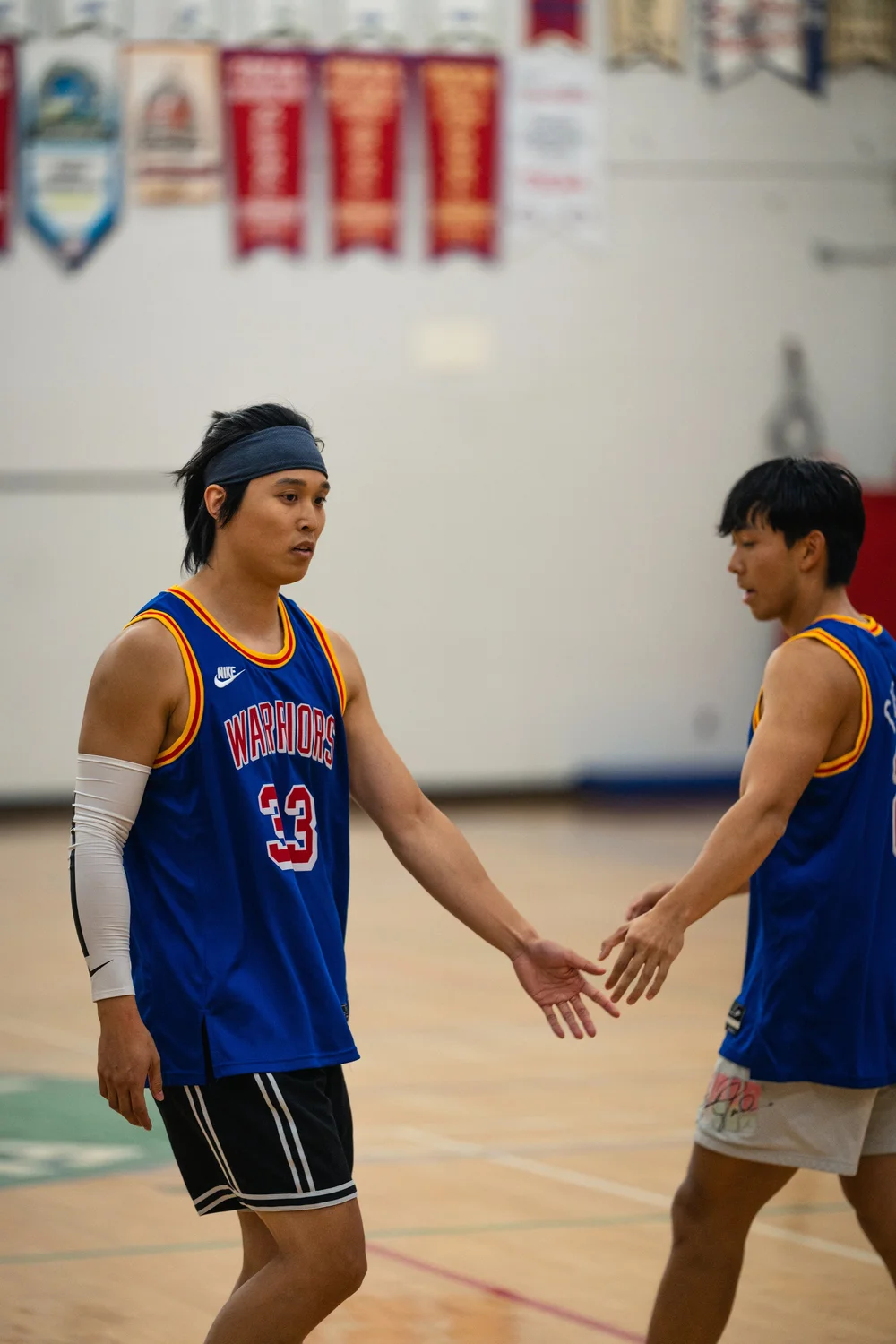 Warriors number 33 extends a hand toward another blue-shirted player.