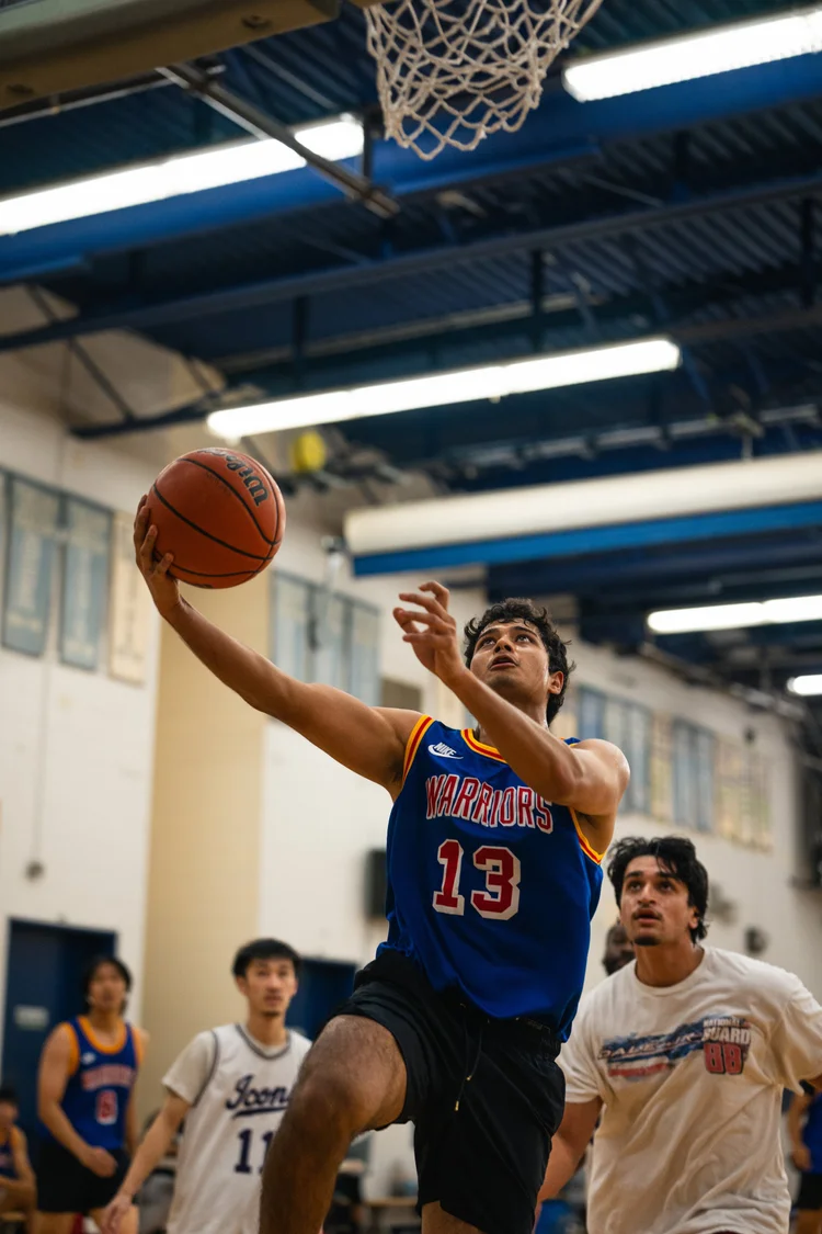 Warriors number 13 raises the basketball for a close-range attempt beneath the hoop.