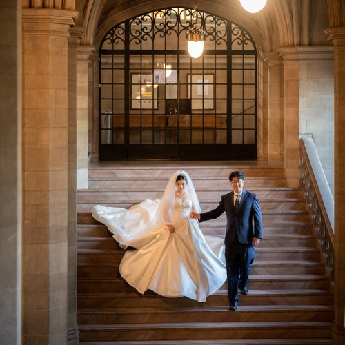 Couple descending a stone staircase beneath a vaulted ceiling