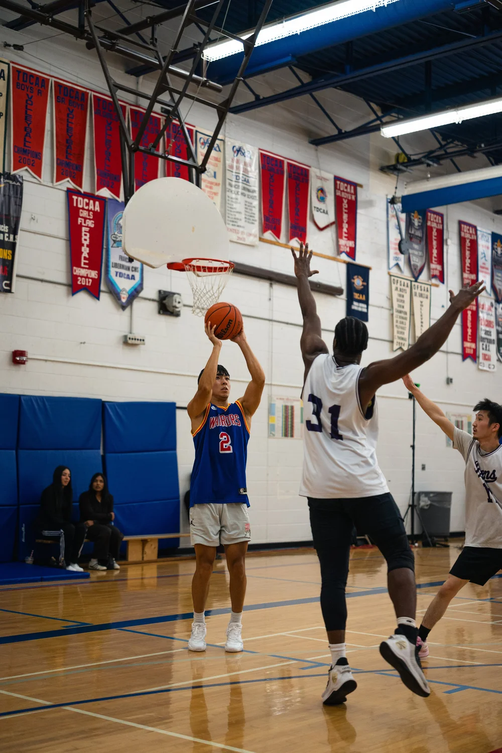 Warriors number 2 prepares a shot as Icons B number 31 jumps with both arms spread.