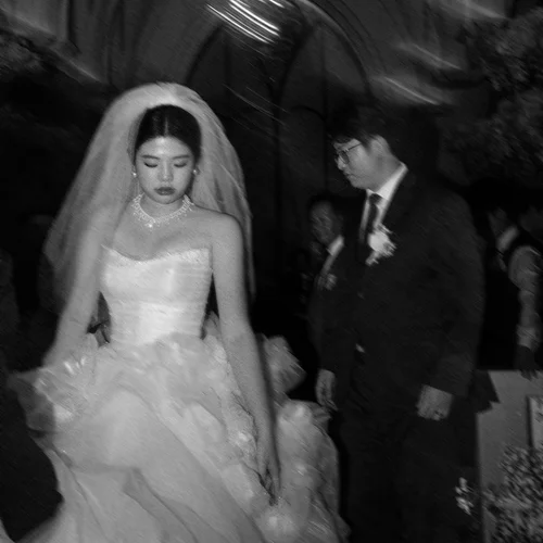 Black-and-white photograph of a couple walking together indoors