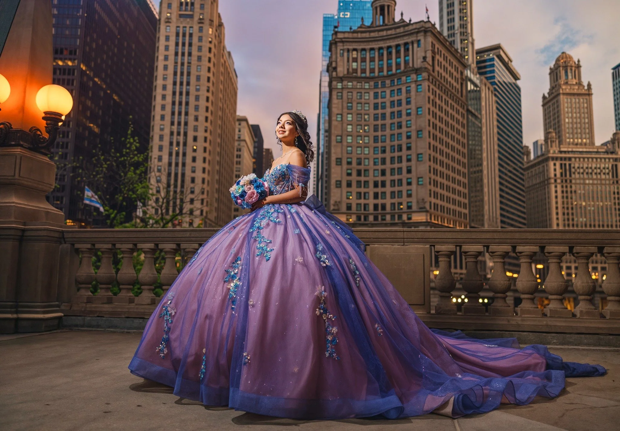 Kamilah in a lilac and blue quinceañera gown with the Chicago skyline behind her
