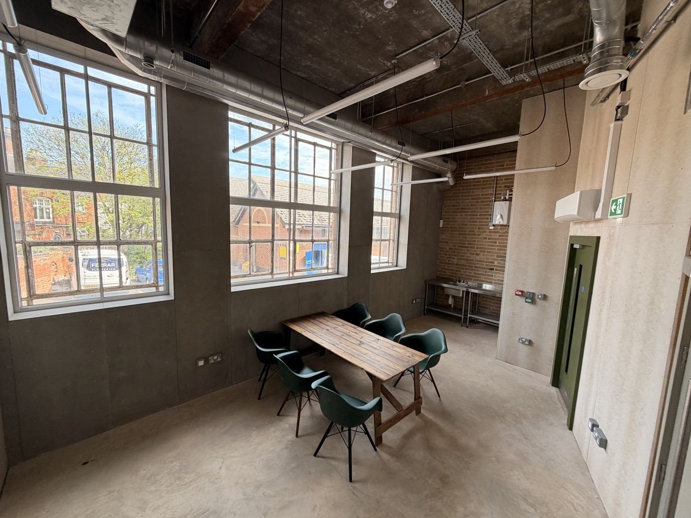 Studio One with large sash windows, table and chairs
