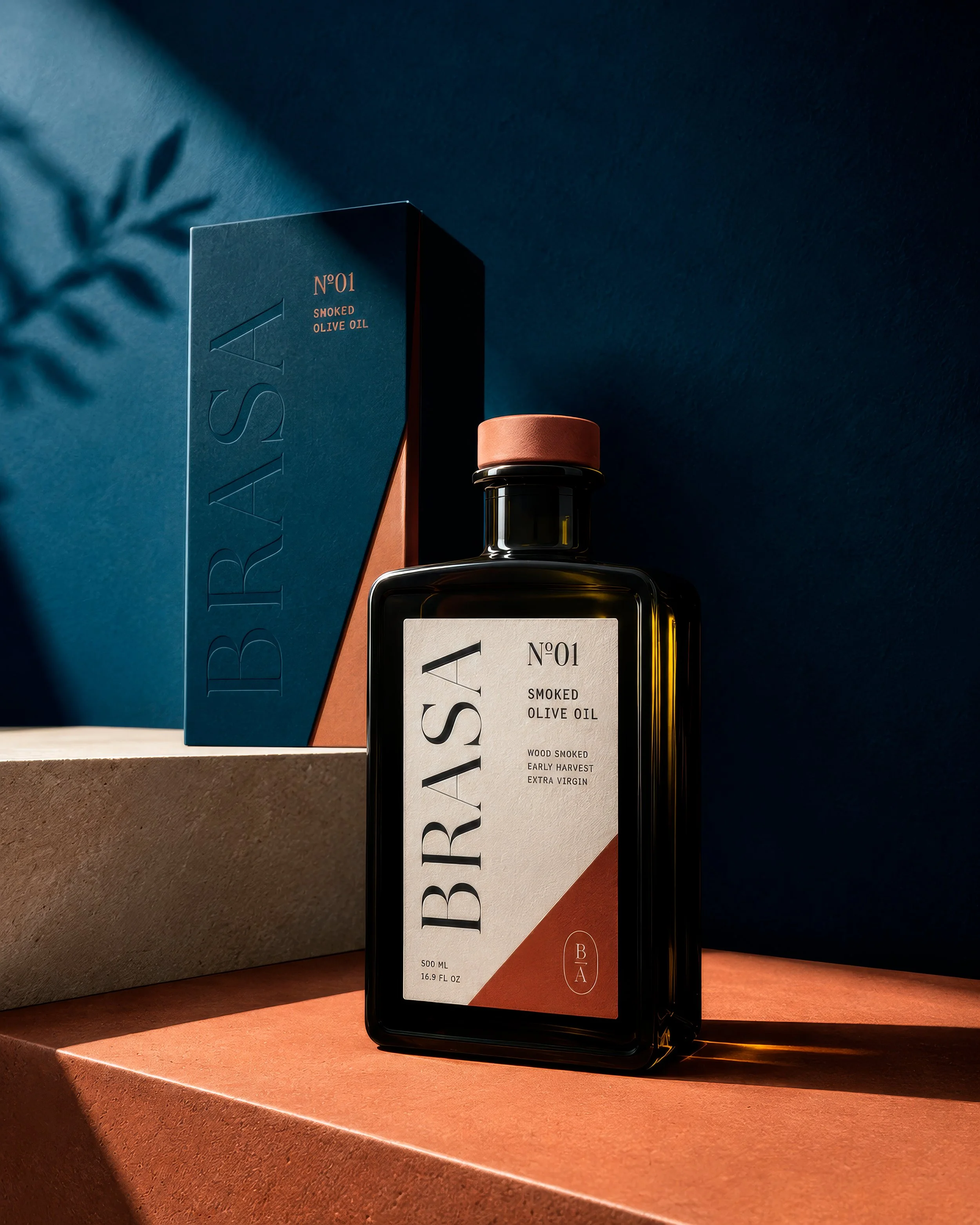 Botella de aceite BRASA y su caja azul, iluminadas sobre una superficie terracota.