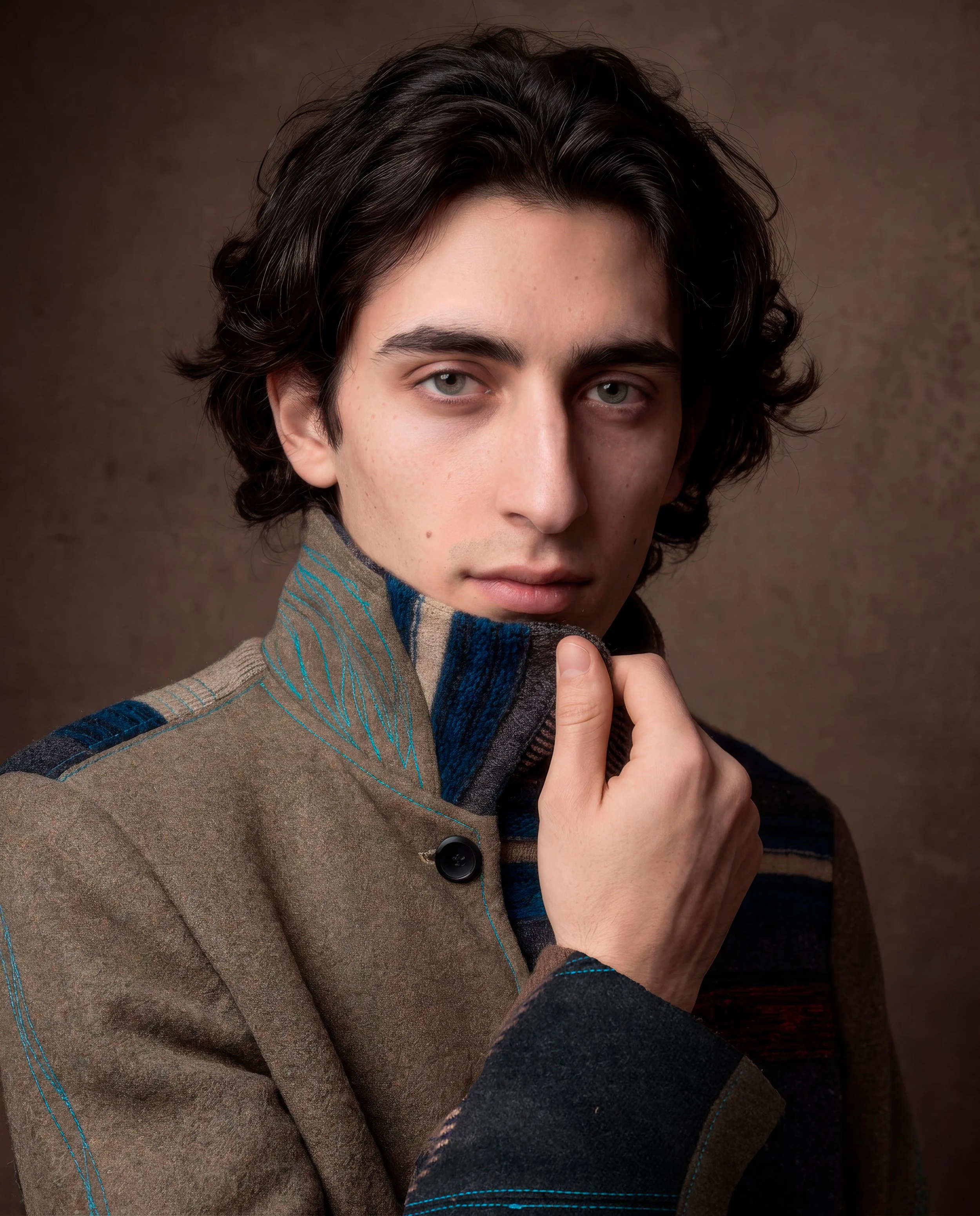 Retrato cercano de un hombre con abrigo claro, con el cuello y la textura del tejido visibles.
