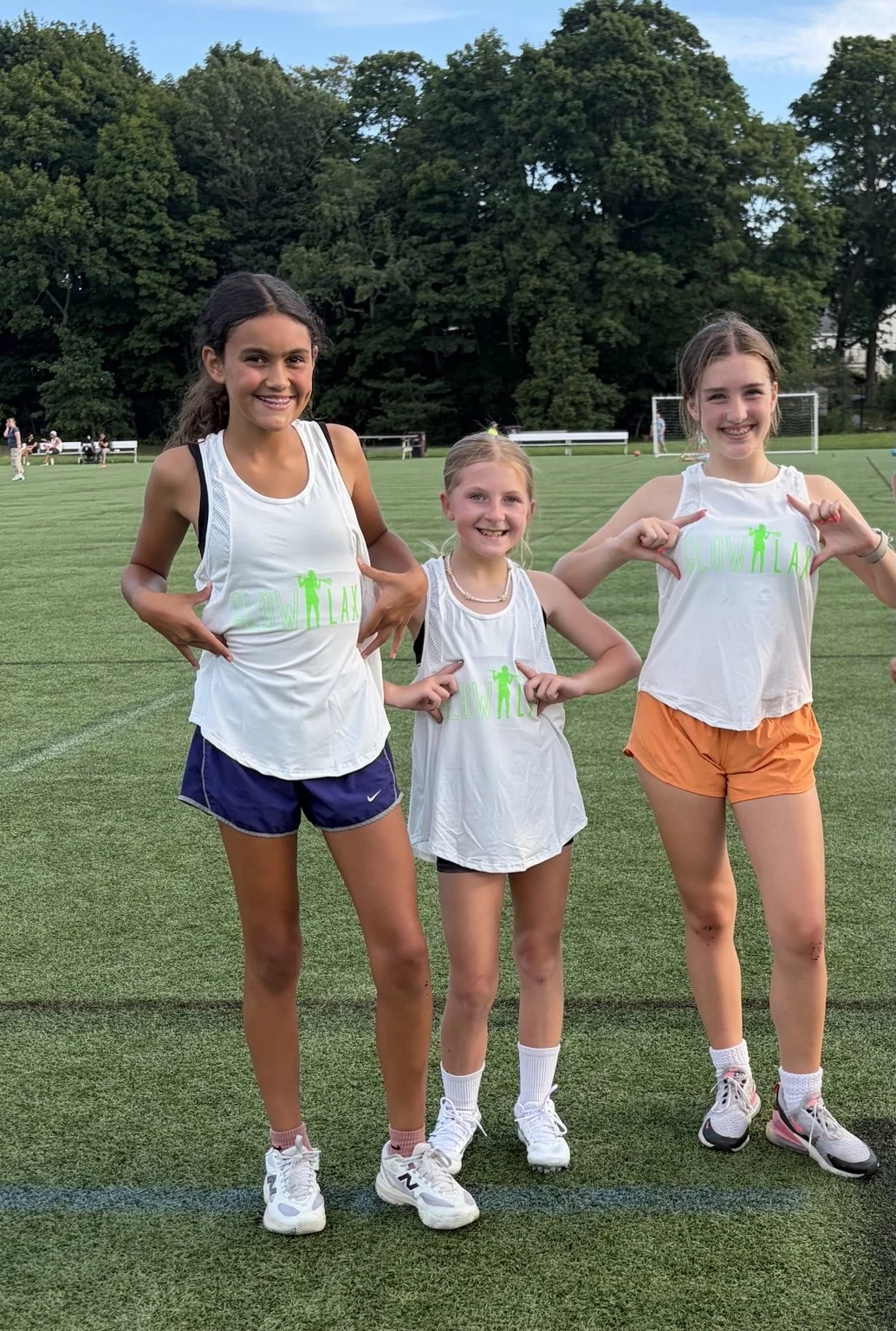 Three older GLOW players standing together and smiling at the camera, shown head to toe.