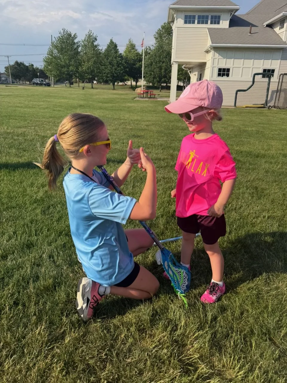 Two young girls in pink and blue high-fiving at GLOW.