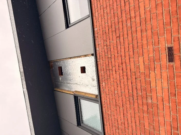 Cladding panel removed beside a window to expose the wall build-up behind