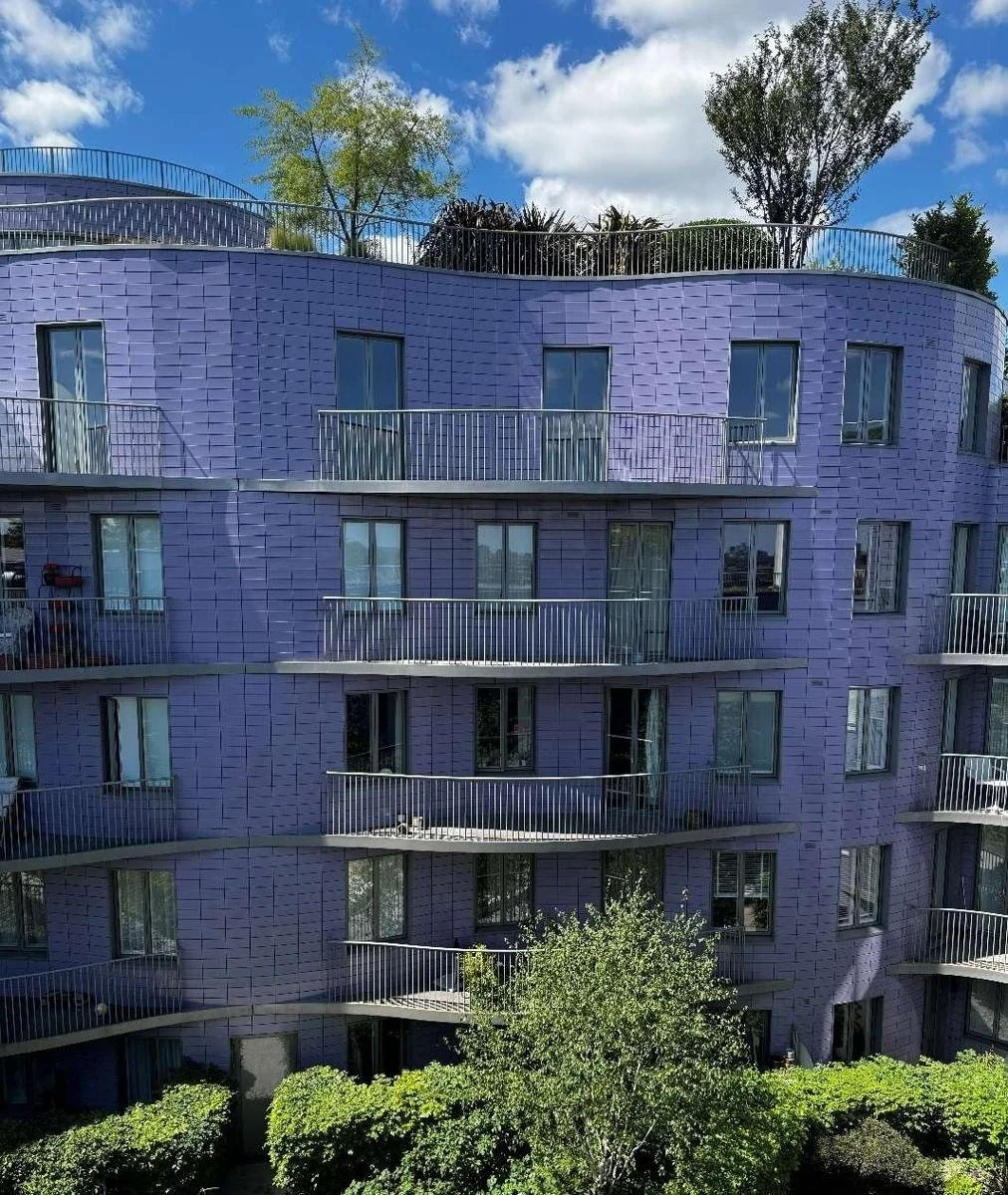Curved terracotta rainscreen elevations of Islington Square Block C seen from the garden courtyard