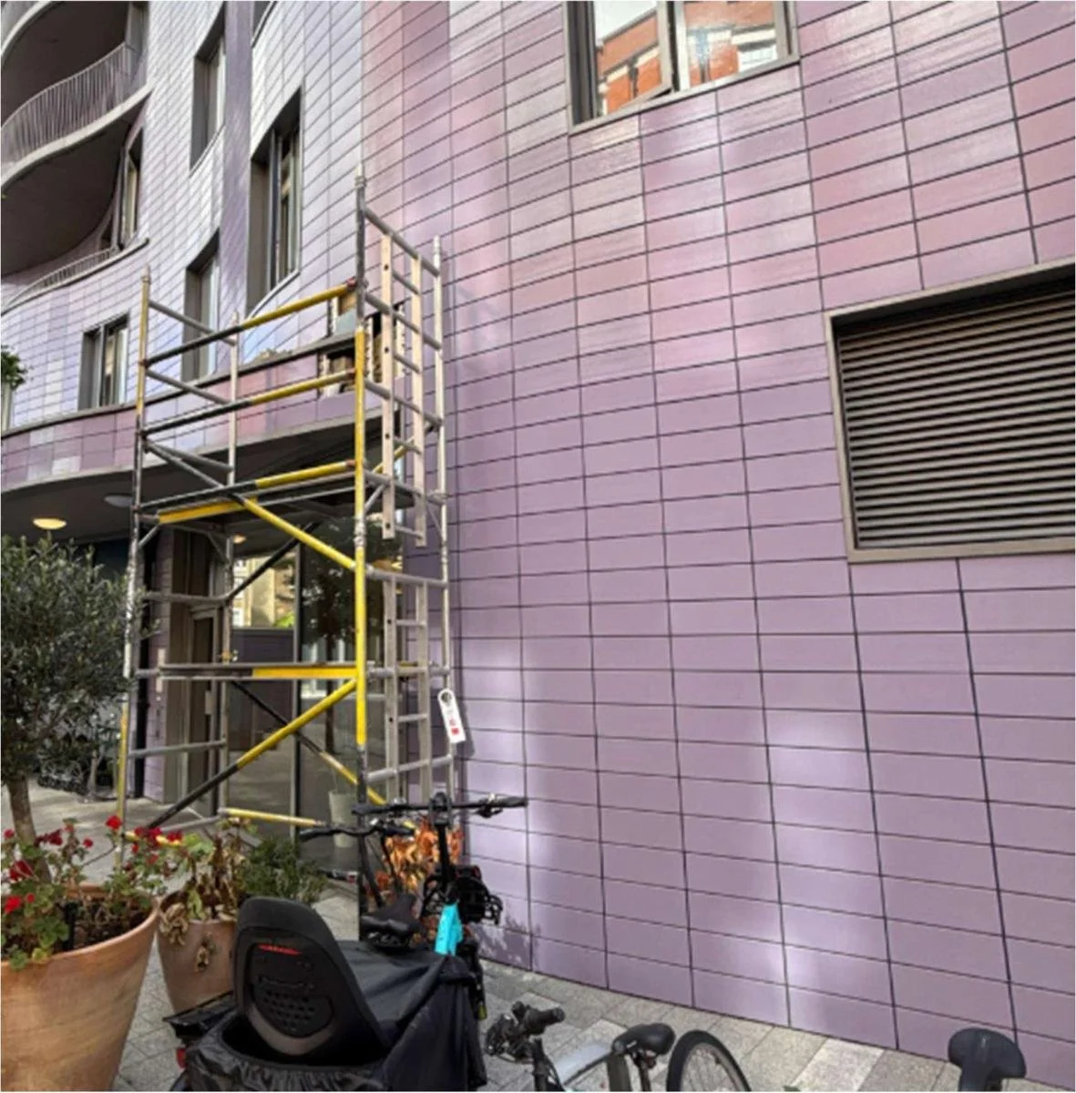 Quick-stage scaffold against the terracotta rainscreen during the survey