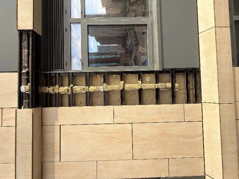 Stone panels removed to expose the horizontal cavity barrier and mineral wool insulation