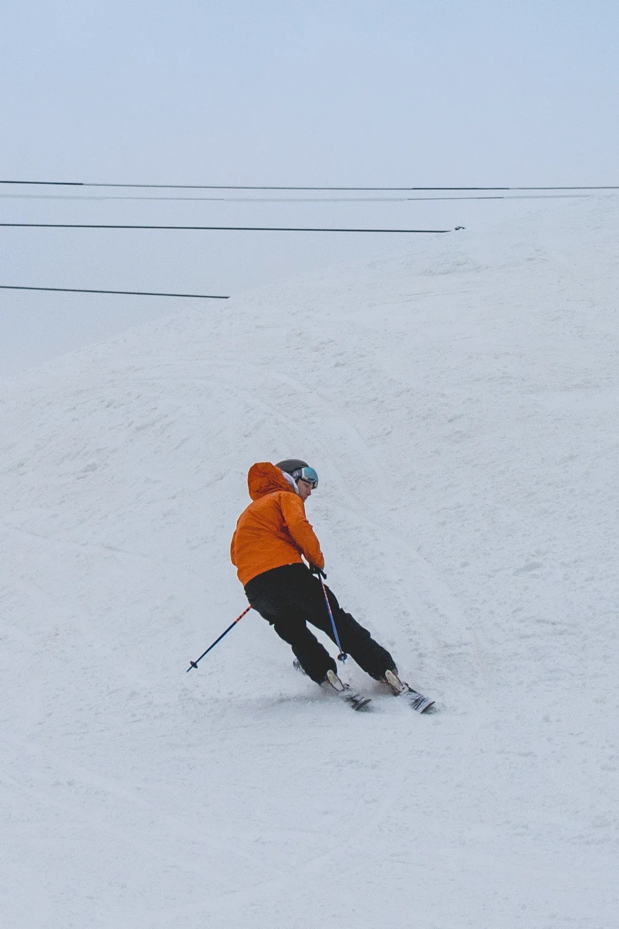 Skier in orange carving on snow