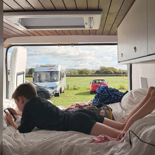 Reading in the campervan bed with the back doors open