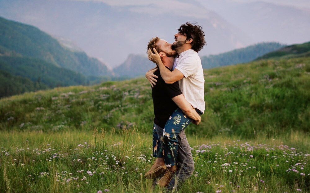Pareja abrazándose en un campo de flores silvestres
