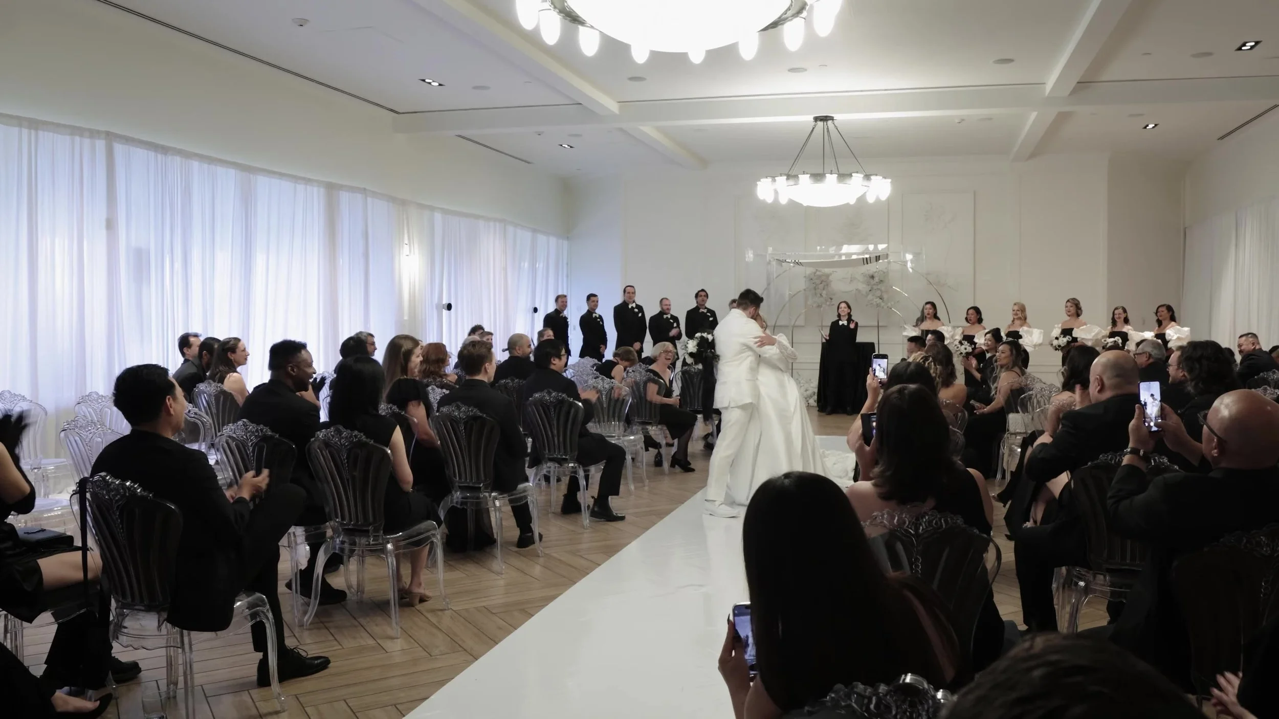 Wide indoor ceremony aisle with Keely and Jay at the altar at Barton Creek Country Club Austin
